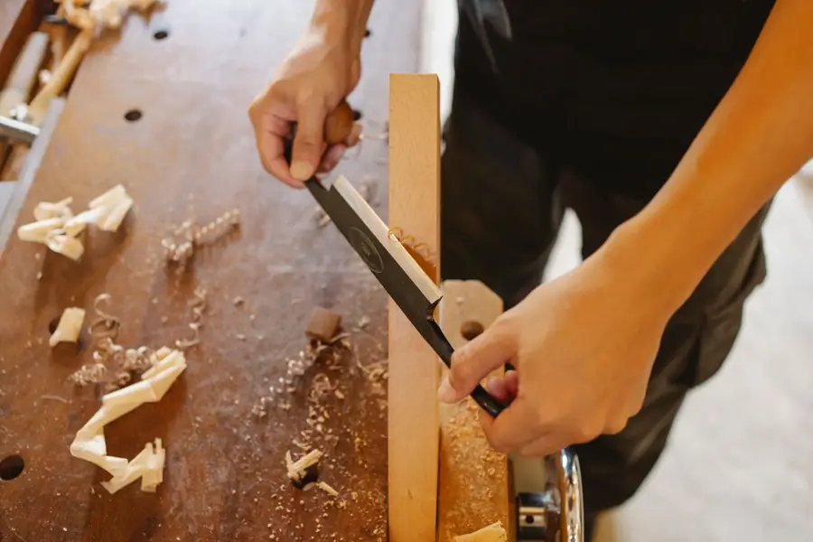 A craftsman cutting a wooden plank, photographed from above — a stock photograph illustrating the scenario.