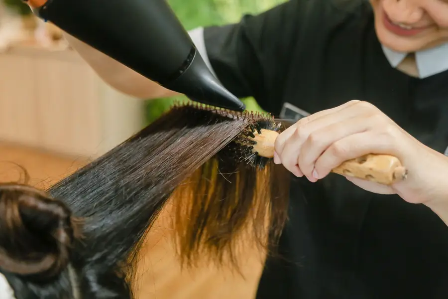 A stylist working at a salon chair — a stock photograph illustrating the scenario.